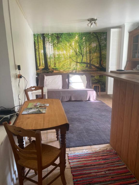 a bedroom with a bed and a table with a table sidx sidx sidx at Studio pour 1 personne au cœur du Perche in Rémalard en Perche