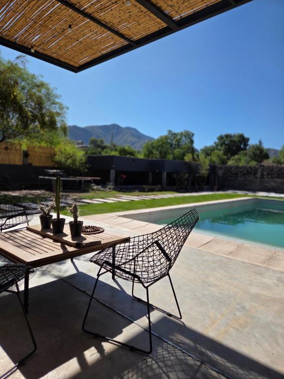 einen Tisch und Stühle auf einer Terrasse neben einem Pool in der Unterkunft Patio Jarilla in El Challao