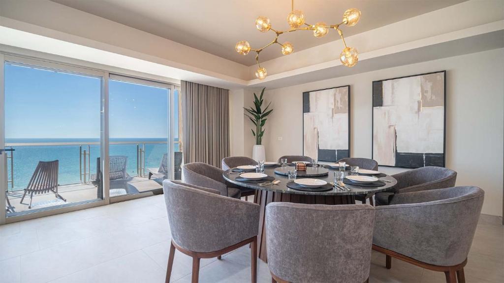 a dining room with a table and chairs and the ocean at Sonoran Star Luxury 3 Bedroom Breachfront Condominium in Puerto Peñasco