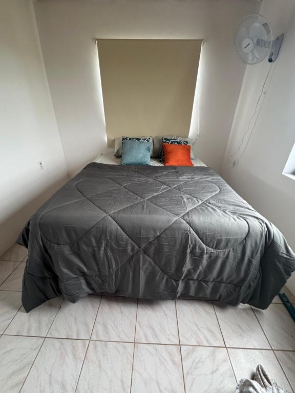 a bedroom with a gray bed with pillows on it at Energia di Trupial in Barber