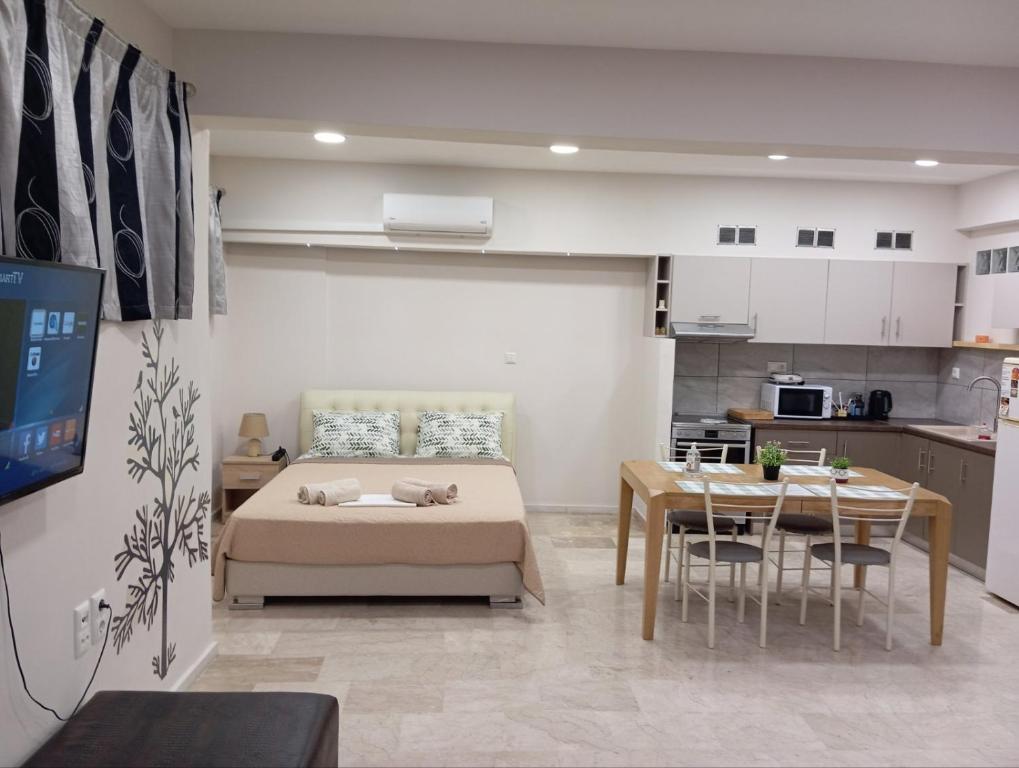 a room with a bed and a table and a kitchen at Elia patra apartment in Patra