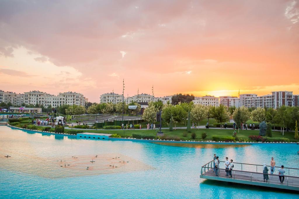 Un puente sobre un río en una ciudad al atardecer en BOULEVARD rentals, en Tashkent