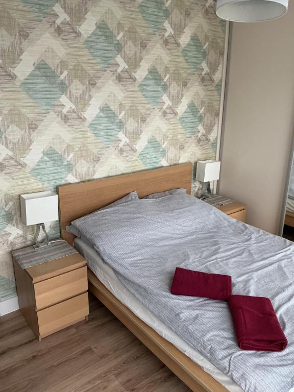 a bedroom with a bed with two night stands and two lamps at Apartament Wygodny 2 in Białystok