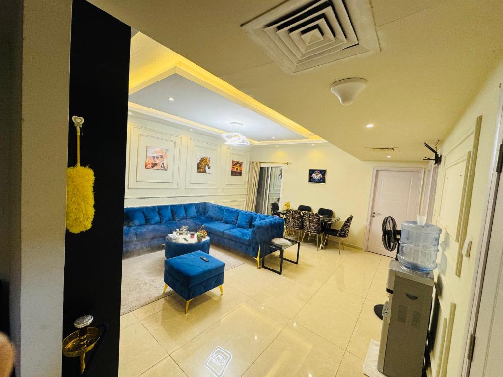 a living room with a blue couch and a table at شقة فندقية غرفة وصالة in Sharjah