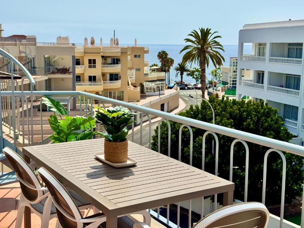 a table and chairs on the balcony of a apartment at Poseidon Dreams Tenerife in Puerto de Santiago