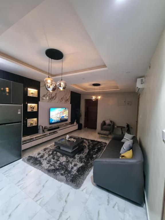 uma sala de estar com um sofá e uma TV em 1 Bedroom Apt Sabolak Suite Sapphire em Ikate