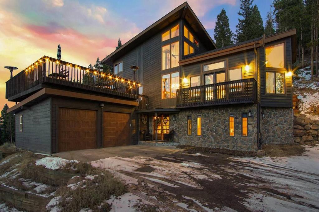 a large house with a balcony and a garage at New. Top of the World Lodge. Hot tub. Theater. in Evergreen