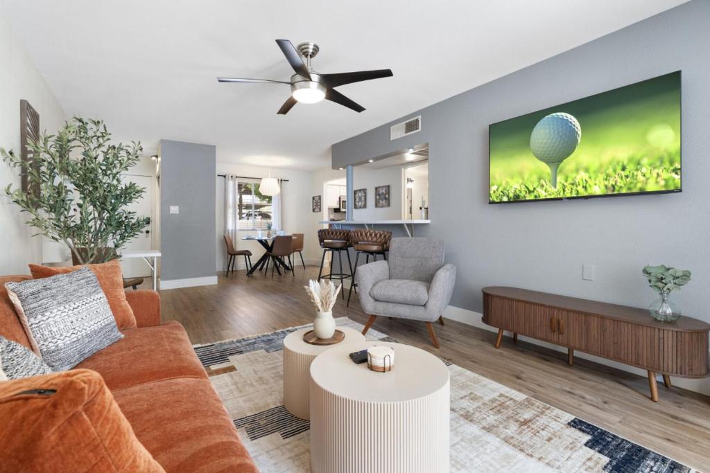 a living room with a couch and a tv on a wall at Walk to Old Town - 1BR Condo, Heated Pool and Patio in Scottsdale