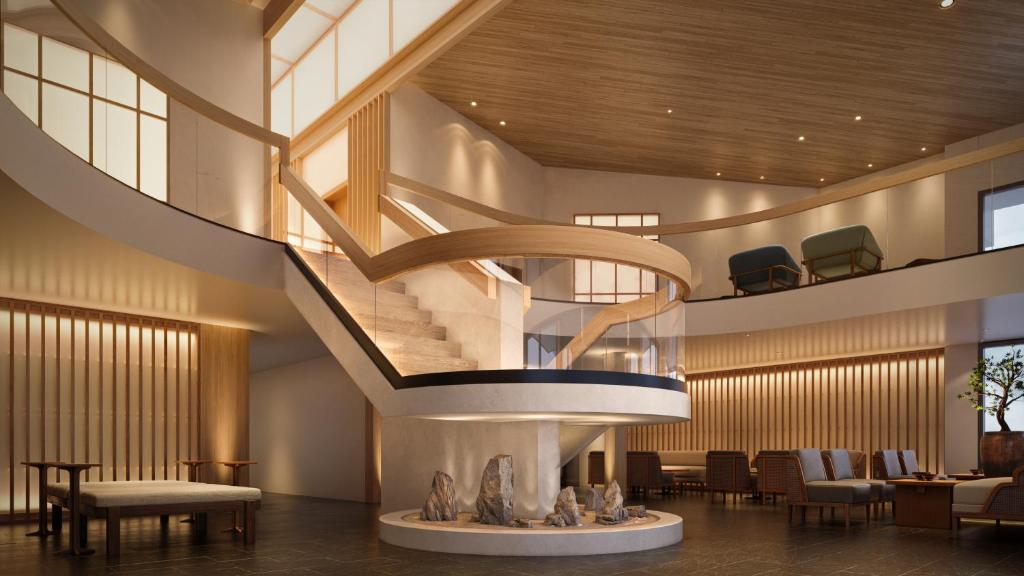 a spiral staircase in a lobby with tables and chairs at The Amaya - 21 and older only in Fort Wayne