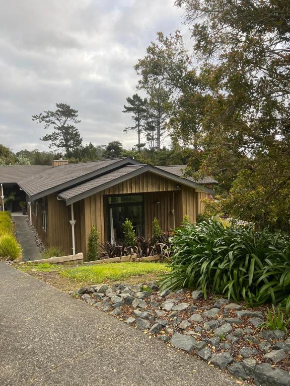 a wooden house with a porch and a driveway at Sandspit Hideaway in Sandspit