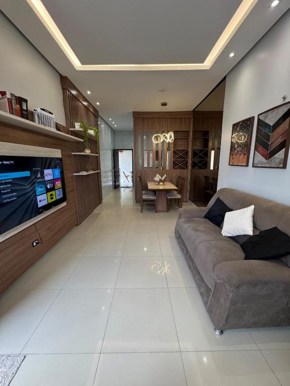 a living room with a couch and a flat screen tv at Casa no Jardim Abrel in Santa Inês