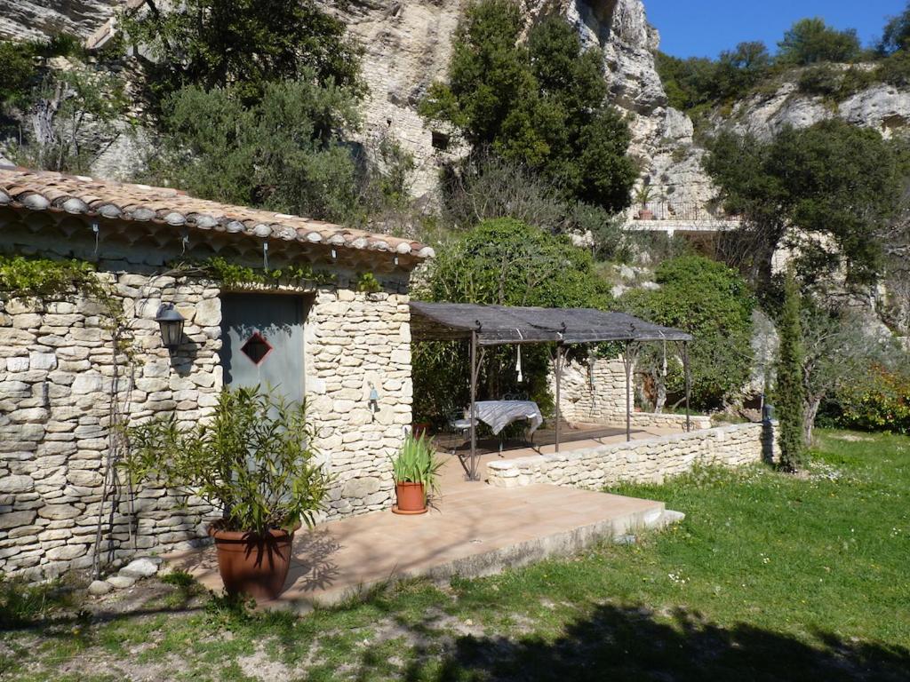 une maison en pierre avec une table et un banc dans l'établissement La Baumo 1 und 2, à Le Beaucet