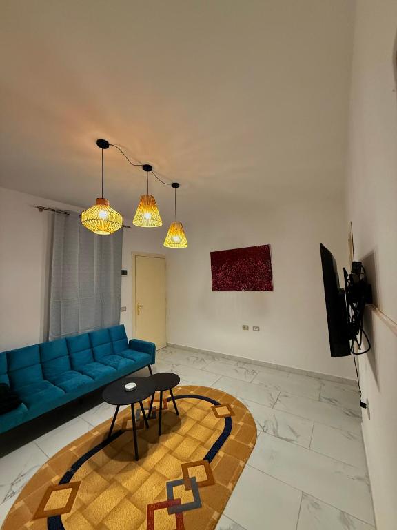 a living room with a blue couch and a table at The Journey Inn in Shkodër