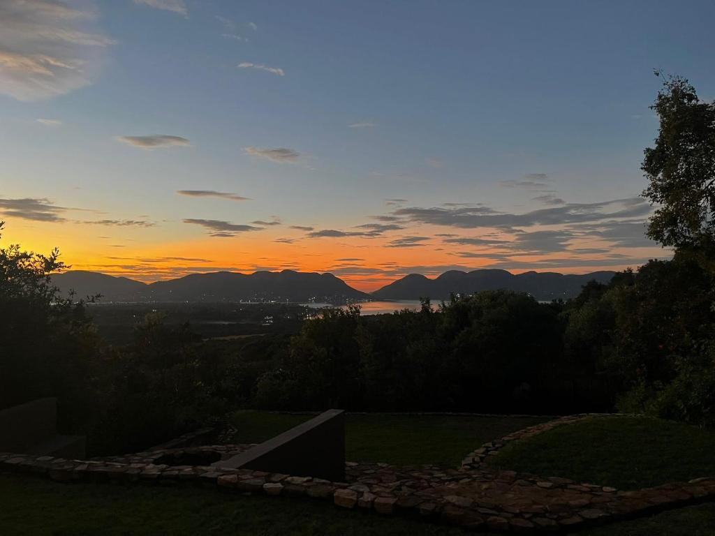 una vista de la puesta de sol desde el patio trasero de una casa en Anahata Nature Resort, en Hartbeespoort