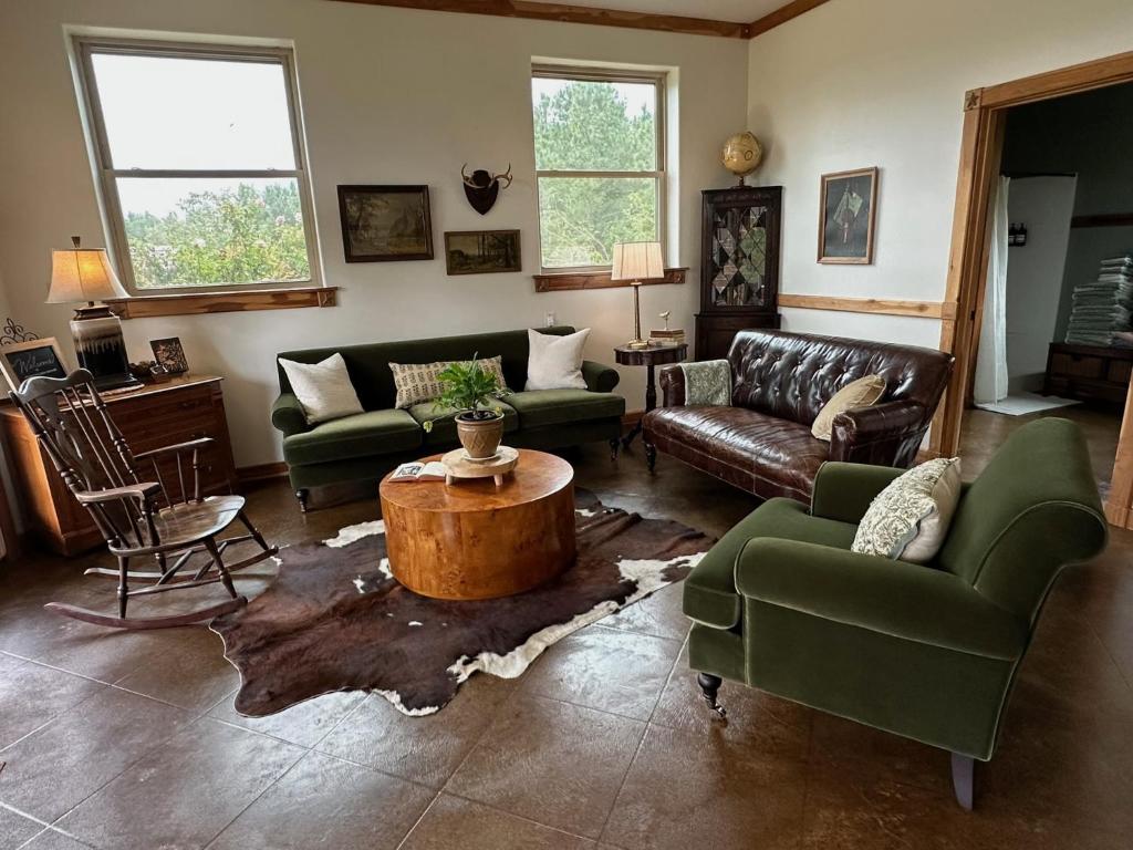 ein Wohnzimmer mit Sofas und einem Couchtisch in der Unterkunft Whispering Pines Retreat, Secluded Cabin with Hot Tub & Pond in Jacksonville