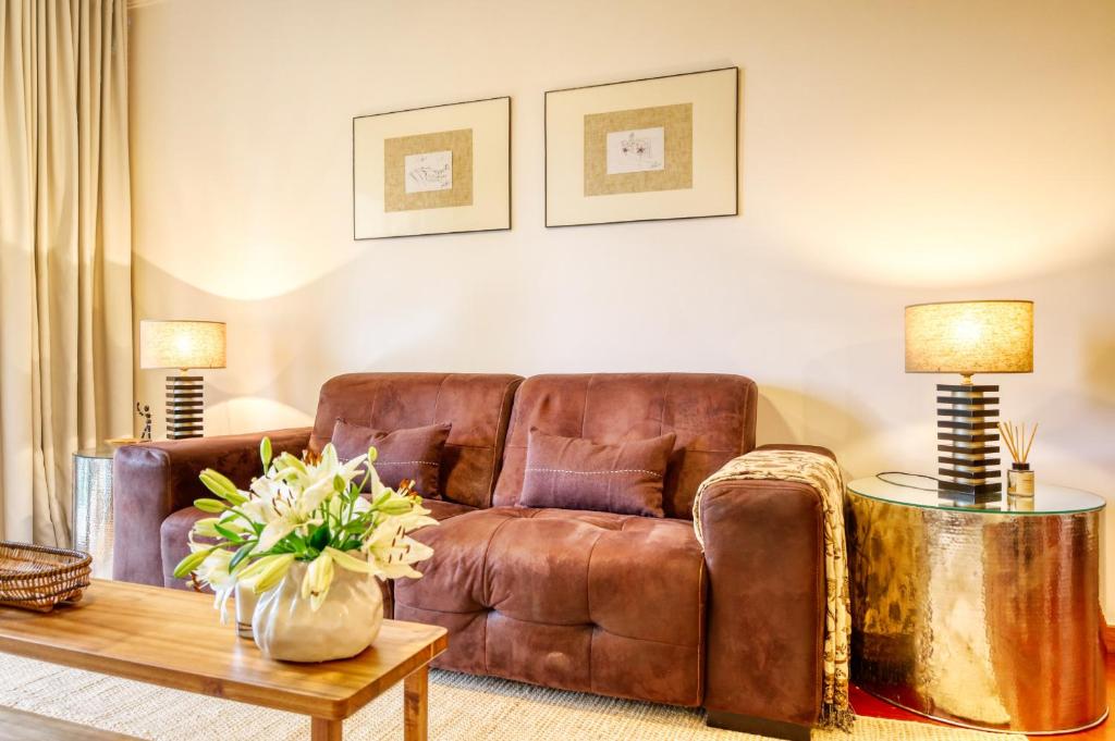 a living room with a brown leather couch and a table at Alzira's Place, a Home in Madeira in Quinta do Almeida