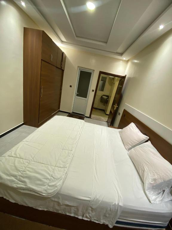 a bedroom with a large white bed in it at Residence el michouar in Laayoune