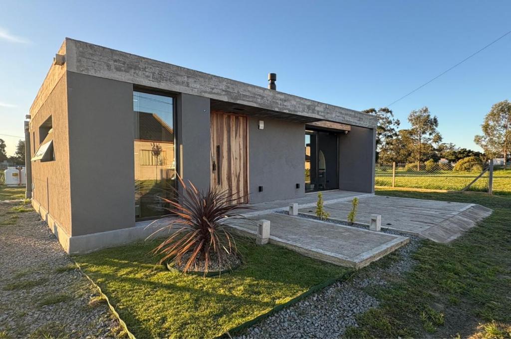 una pequeña casa con una palmera delante de ella en Casa las lomas, en Miramar