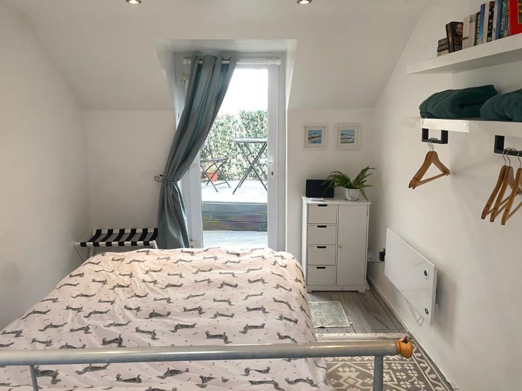 a white bedroom with a bed and a window at Cozy 1 Bed Retreat - Amlwch in Amlwch