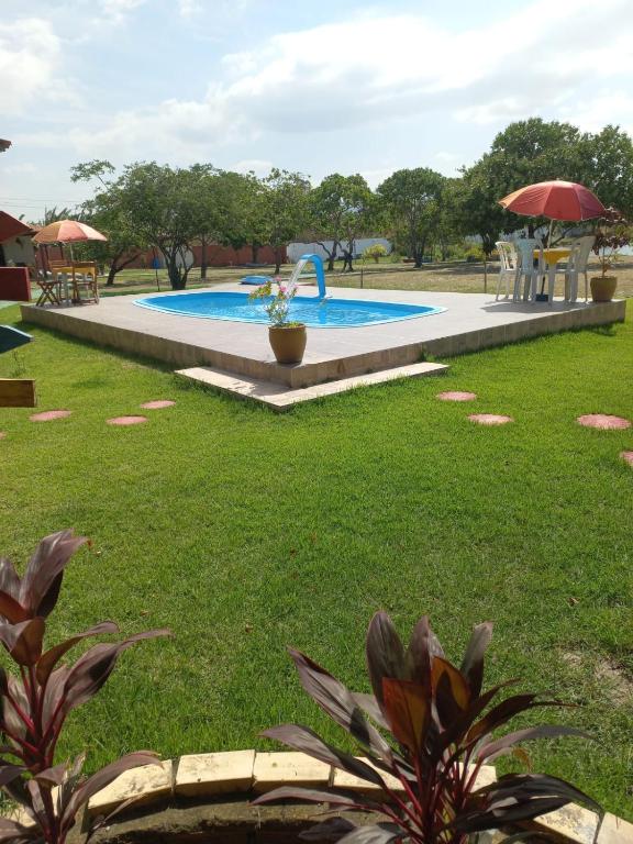 a swimming pool in a grassy yard with a playground at Pousada Sítio Boas Novas in Caucaia