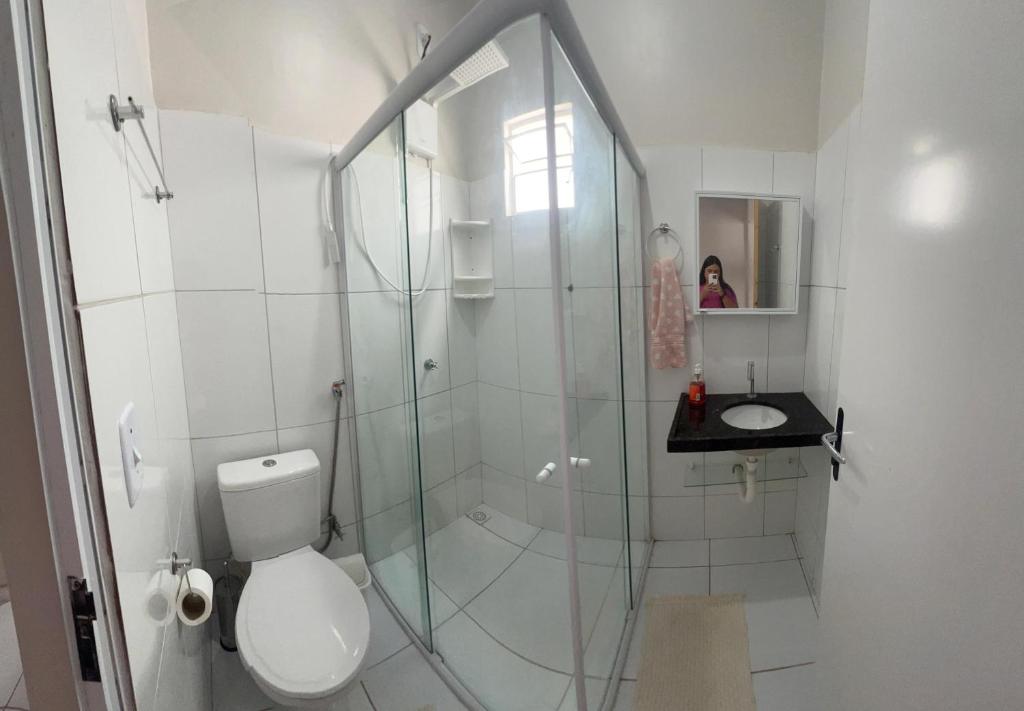 a bathroom with a shower with a toilet and a sink at Casa Jardins in Barreirinhas