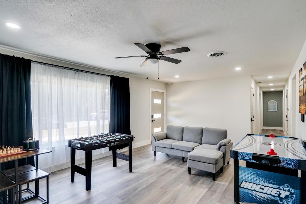 a living room with a couch and a ceiling fan at Backyard and Game Room! Home in Heart of Midland in Midland Airpark