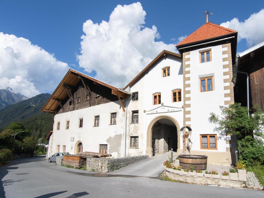 a large white building with a wooden roof at Schloss Sissi - S in Pfunds