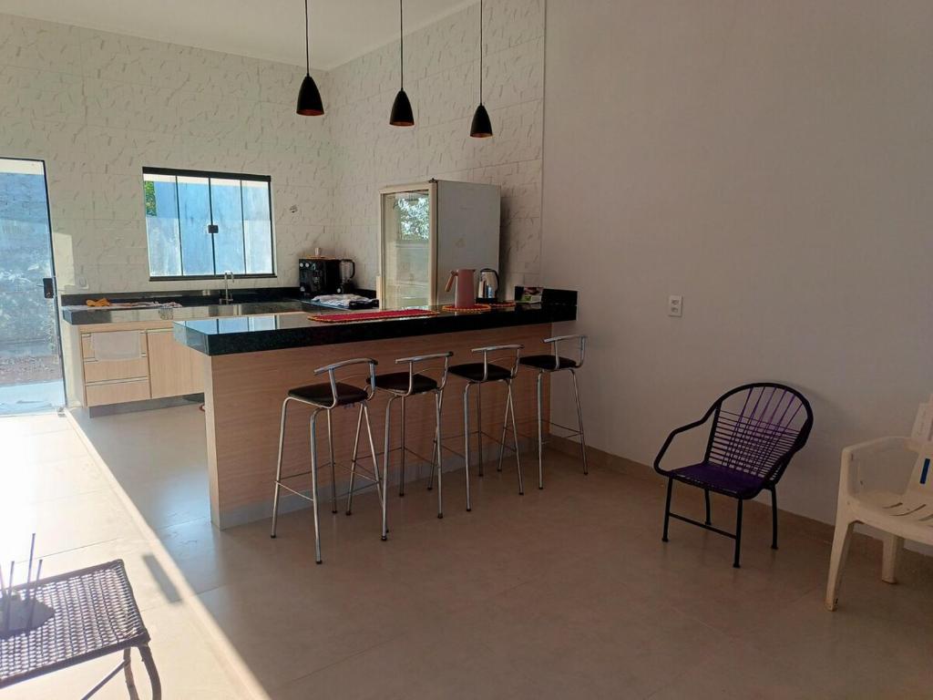 cocina con taburetes y encimera en Casa no Residencial Marlene Vaz com 2 quartos, en Porangatu