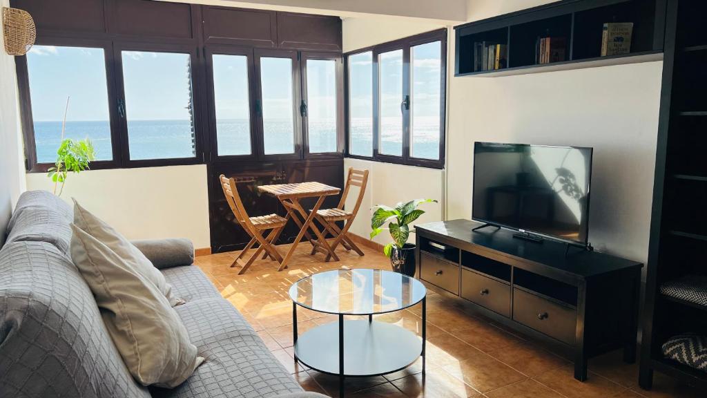 a living room with a couch and a tv and a table at Balcón del Mar in Arrecife