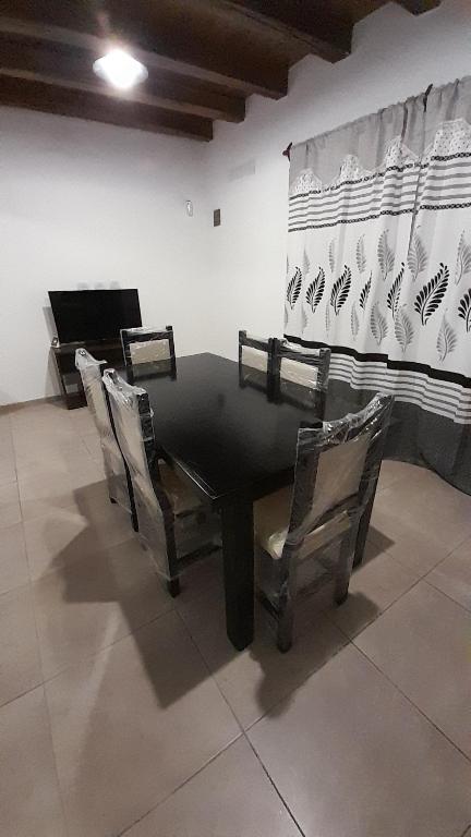 a table with chairs and a piano in a room at Sol de Abril in Russell