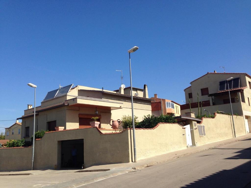 un edificio al lado de una calle con dos luces en Can Municoy, en Castelló d'Empúries