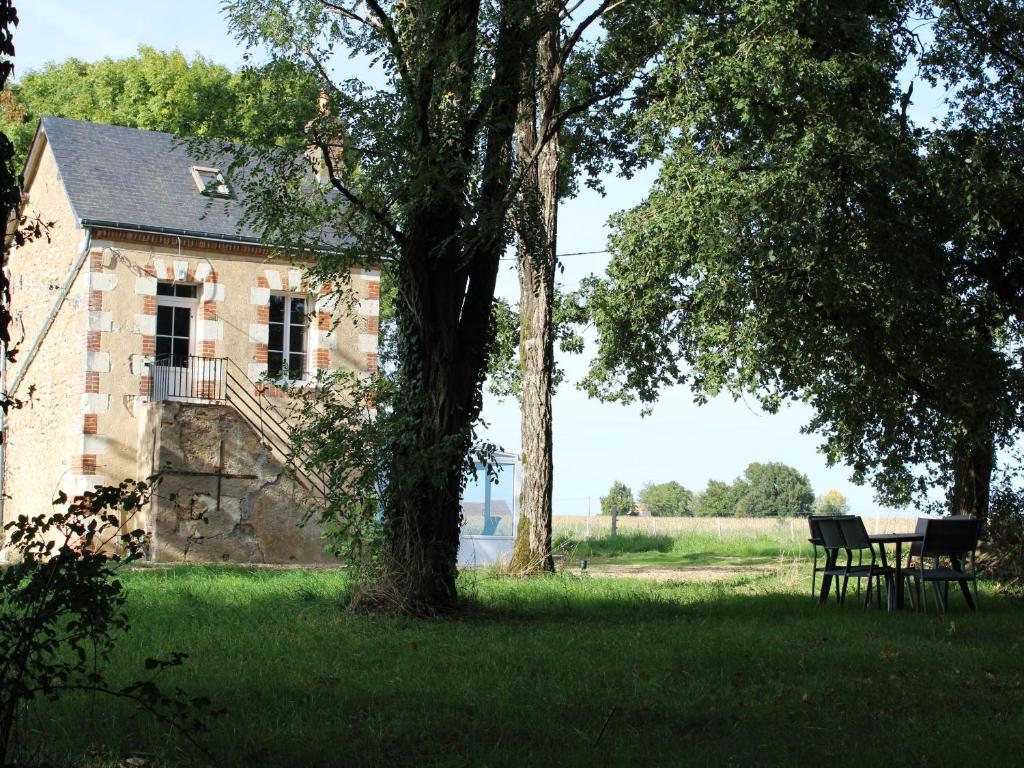 einen Tisch und Stühle vor einem alten Gebäude in der Unterkunft Charme champêtre entre Le Mans et Tours, maison rénovée en pleine nature - FR-1-410-480 in Flée