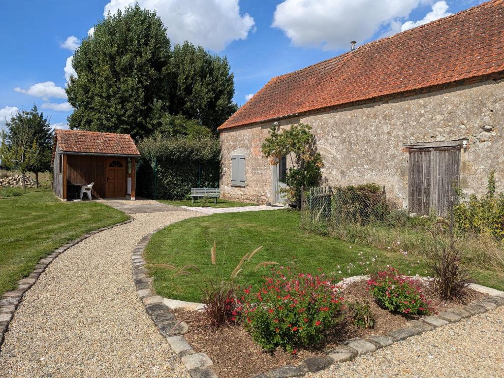 una casa in pietra con un giardino accanto a un edificio di Gîte cosy en Val de Loire, proche Loire, Sologne, Sully/Loire - 1 ch, salon, cuisine, linge inclus - FR-1-590-30 a Guilly
