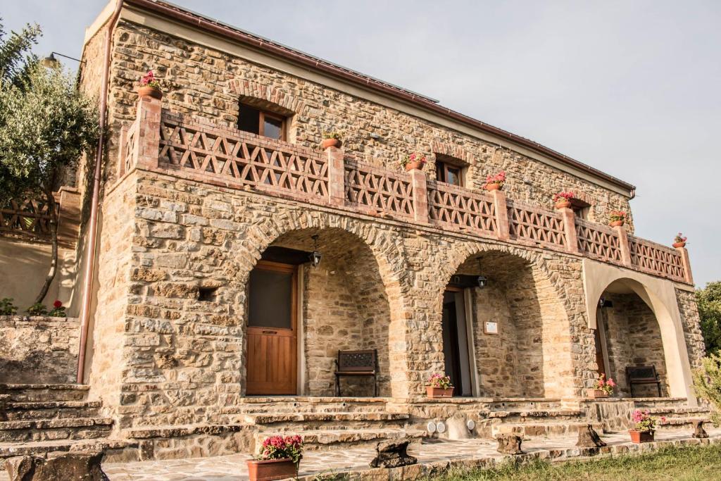 a stone house with a balcony on top of it at Casale storico nella campagna cilentana in Rutino