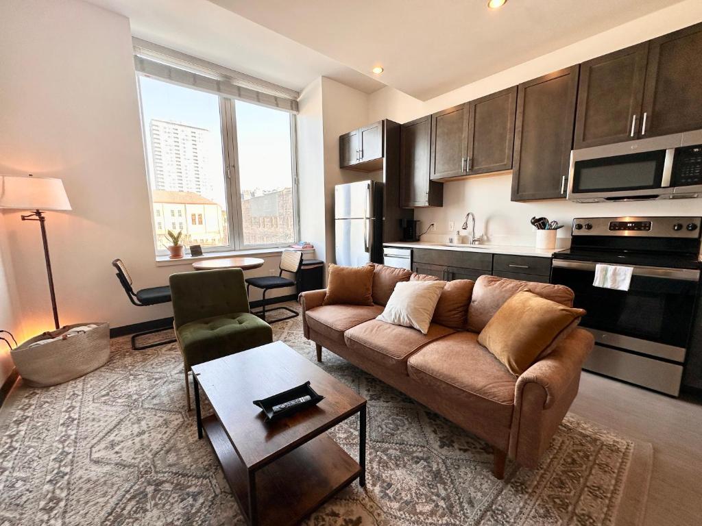 a living room with a couch and a kitchen at Deer District Studio Apt - One Block from Fiserv and Baird in Milwaukee