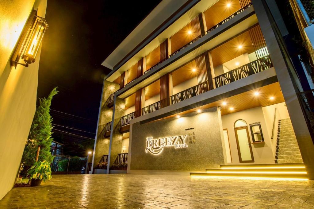 ein Gebäude mit einem Schild an der Seite in der Nacht in der Unterkunft The Breezy Hotel in Muaklek