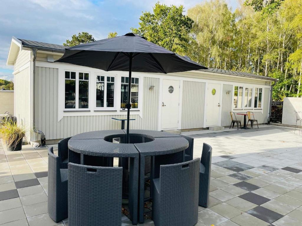 Una mesa y sillas con una sombrilla en un patio. en 4 star holiday home in SÖLVESBORG, en Hällevik