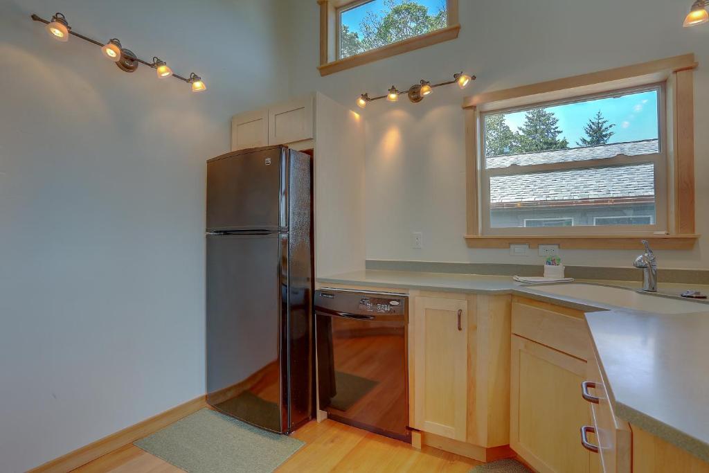 a kitchen with a refrigerator and a sink at Hutson's Bridgeview House with HotTub & Huge Walk in Shower - 30 day min home in Hood River