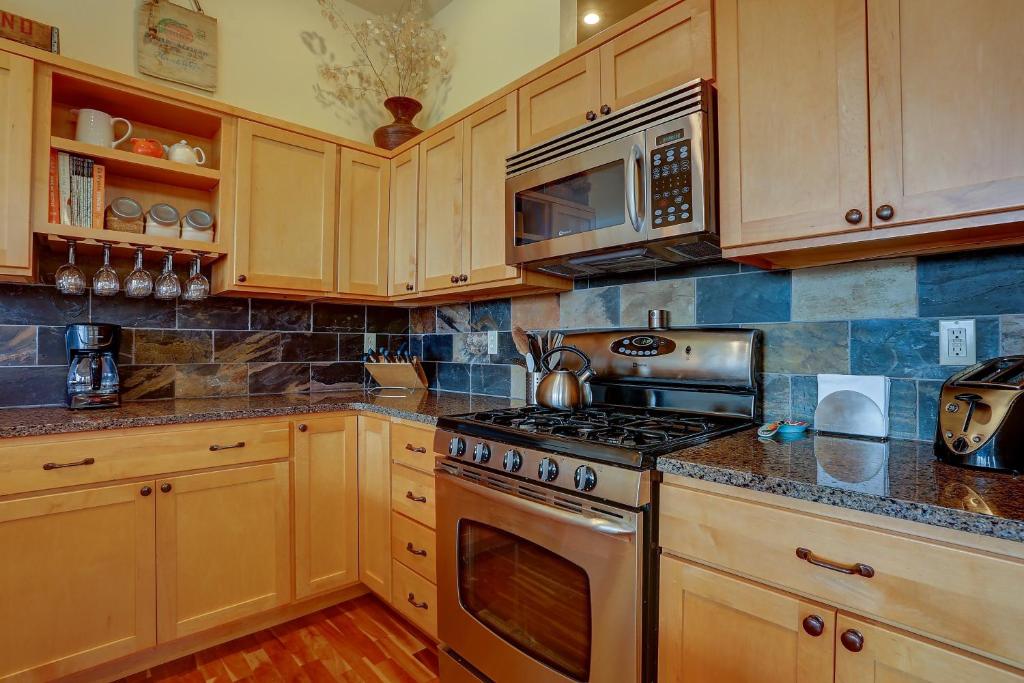 a kitchen with wooden cabinets and a stove top oven at Three Rivers home in Hood River
