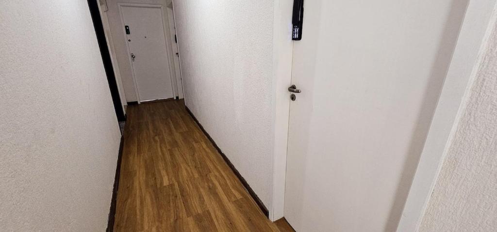 a hallway with white walls and a wooden floor at 100 metros da praia do forte in Cabo Frio
