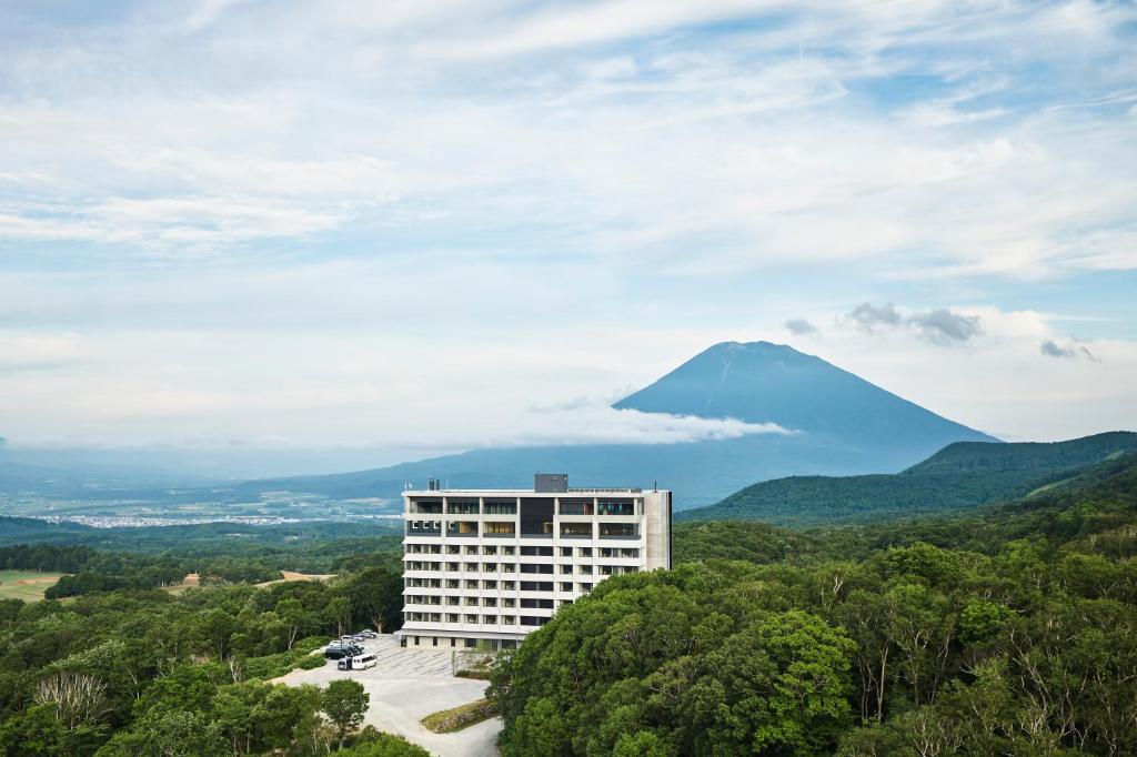 a mountain in the distance with a building in the foreground at Chalet Ivy Weiss, Niseko in Kutchan