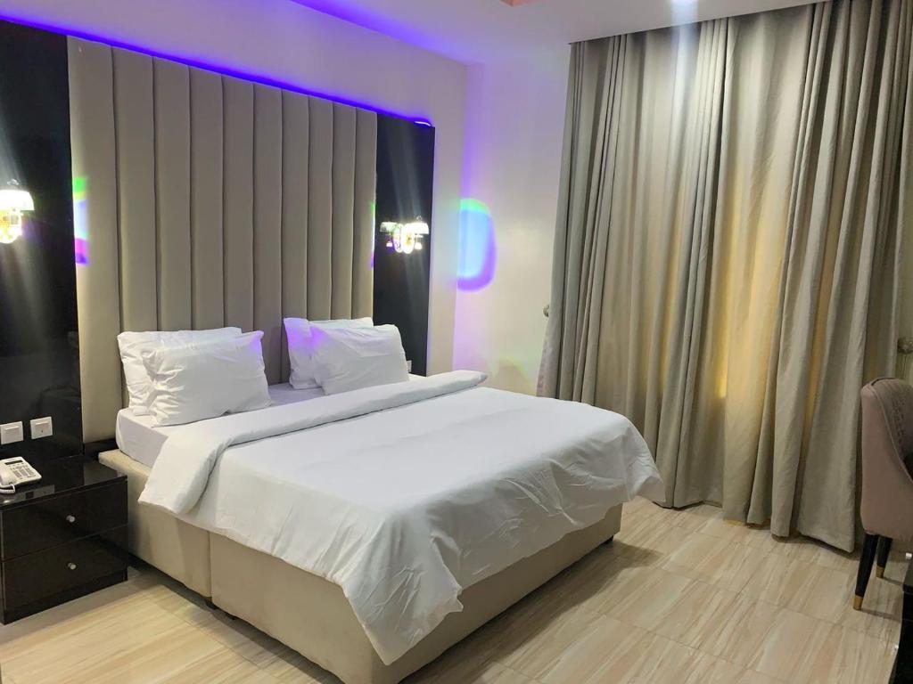 Una cama o camas en una habitación de Gold Rhino Hotel and Suites Ltd