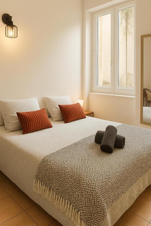 ein Schlafzimmer mit zwei Betten und einem Fenster in der Unterkunft Cosy T1 30m2 avec cour en plein cœur de ville in Marmande