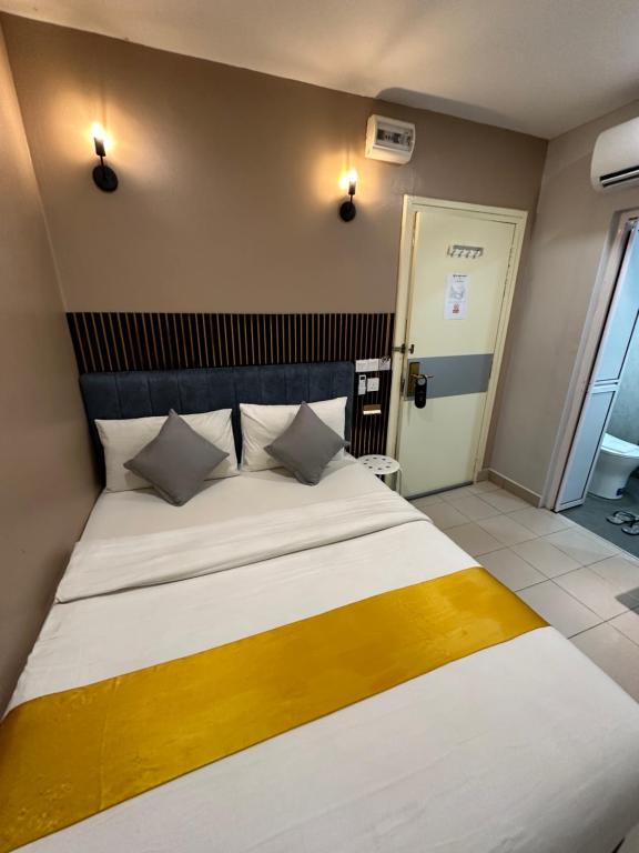 a bedroom with a large bed with a wooden headboard at SS Grey Hotel BBKL in Kuala Lumpur