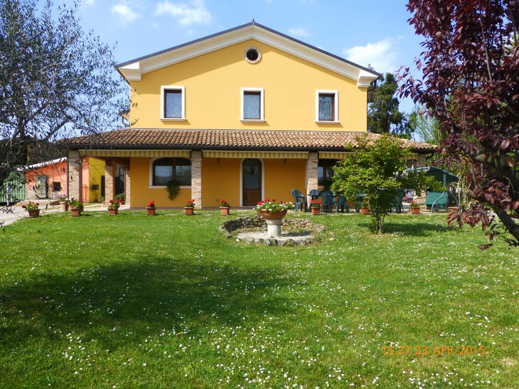 a yellow house with a green yard at Agriturismo Ae Noseare in Torri di Quartesolo
