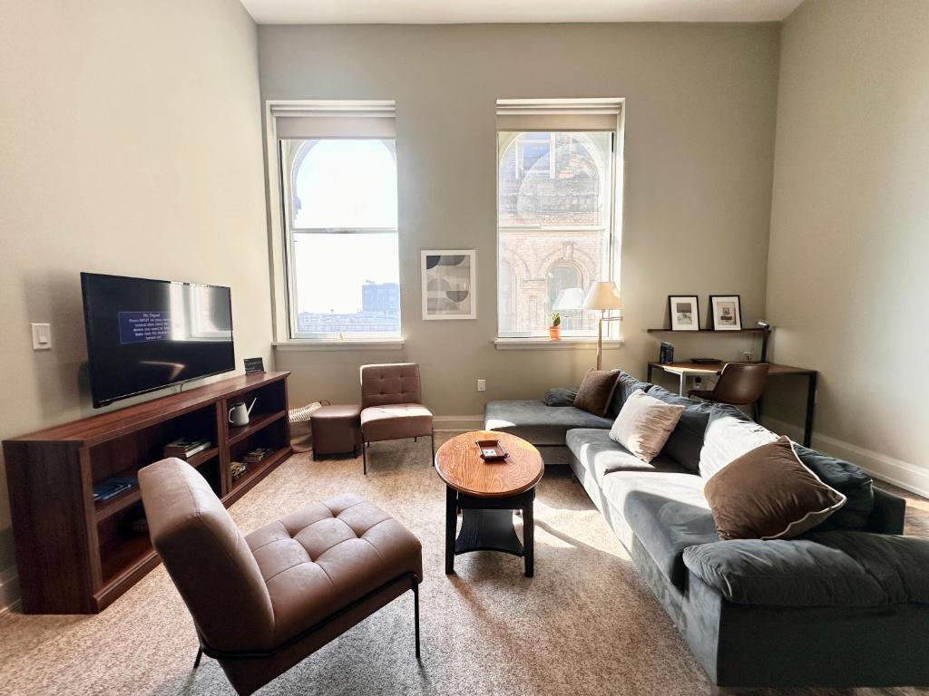 un soggiorno con un divano e una TV di Downtown Sleek 2BR Loft a Milwaukee