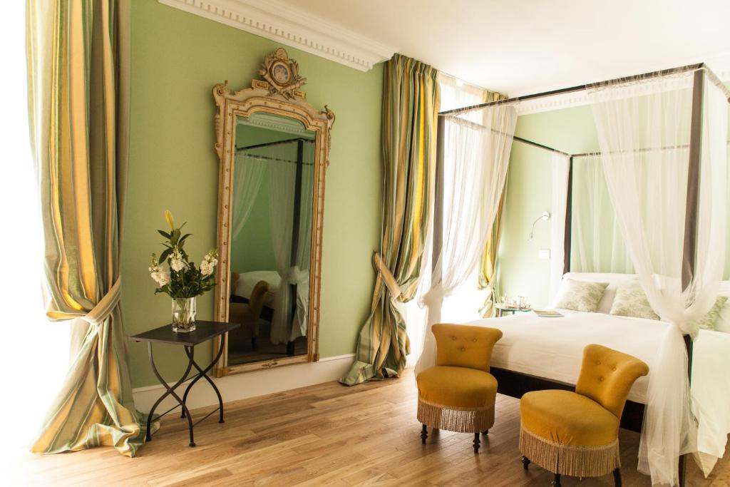 - une chambre avec un lit, un miroir et deux chaises dans l'établissement Palazzo del Senatore, à Atina