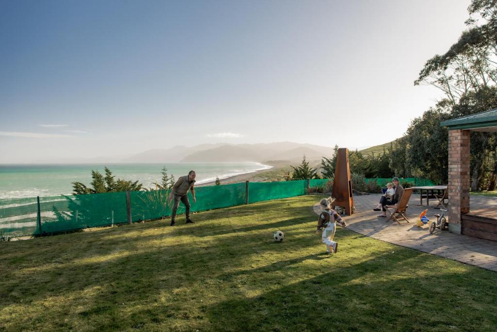 a group of people playing with a soccer ball in a yard at Expansive Ocean & Mountain Views - KK82140 in Kaikoura
