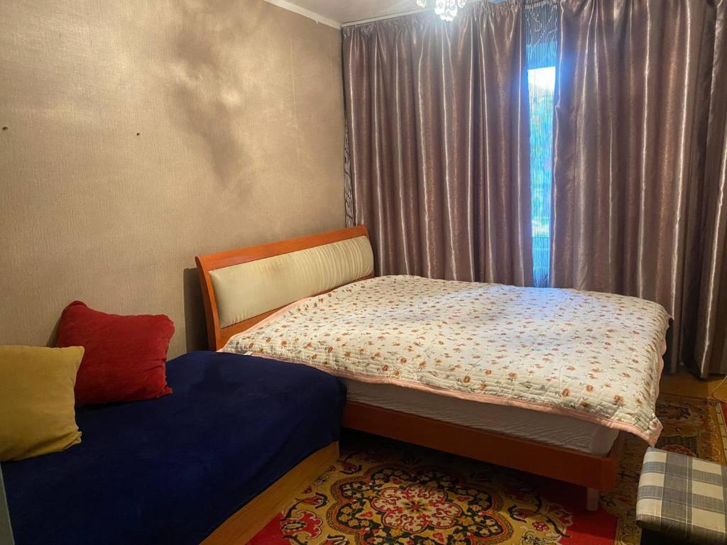 a small bedroom with a bed and a window at Хостел в центре Улан-Батора in Ulaanbaatar