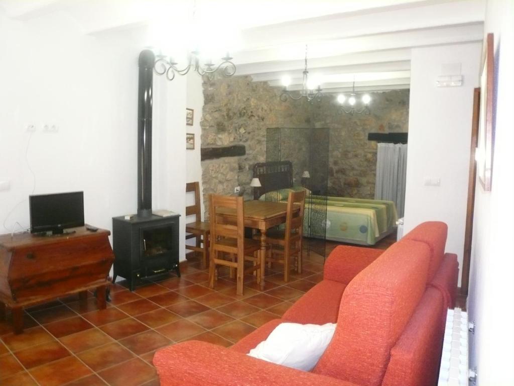 a living room with a red couch and a table at Loft Cuco in Puebla de Benifasar